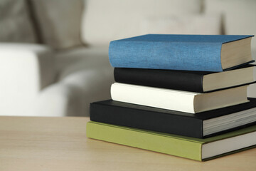 Stack of hardcover books on wooden table indoors, space for text