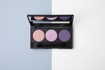Eye shadow palette on colorful background, top view