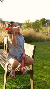 Ni&ntilde;a hermosa latina al aire libre en el parque disfrutando jugando haciendo soplando burbujas sonriendo en un hermoso atardecer al aire libre sorprendida
