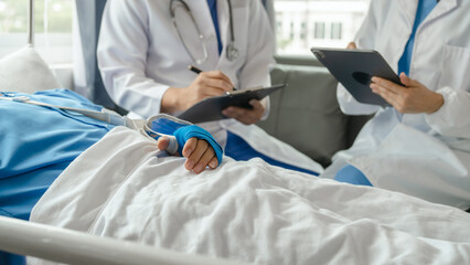 The medical team visits the car accident patients who are lying on the nursing bed and arm cast...