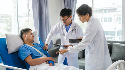 Fototapeta premium The medical team visits the car accident patients who are lying on the nursing bed and arm cast with wrapping nurse bandages splint to the arm.
