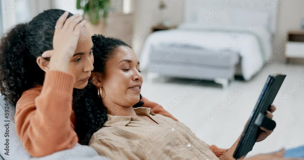 Wall mural Lesbian, couple and women relax on couch with tablet, happy with online streaming service and watching a video or movie. Comfort, bonding and lgbt people spending time together at home on technology