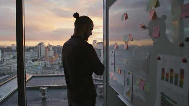 Businessman silhouette thinking notes evening office. Specialist reading tasks