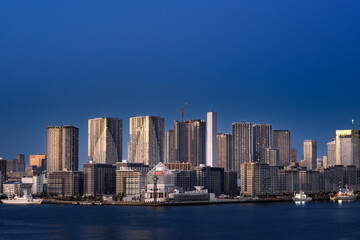 Obraz premium 夕暮れ時の東京湾レインボーブリッジから見る晴海ふ頭とタワマン群