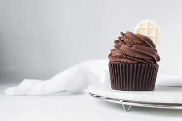 Chocolate cupcake with dark chocolate buttercream, double chocolate cupcakes with american buttercream, tall swirl frosting on a cupcake with a wafer