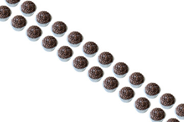 Two strips of Brazilian fudge balls arranged in a diagonal. Brazilian traditional sweet.