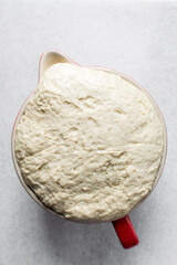Over proofed dough that has risen over the top of bowl, bread dough that has risen for too long,...
