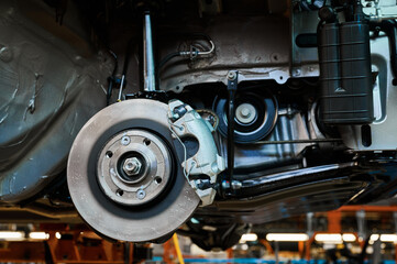 Finished automobile suspension with brake and rotor in shop