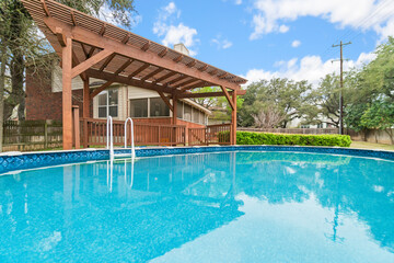 an above ground pool with a covered wooden deck 