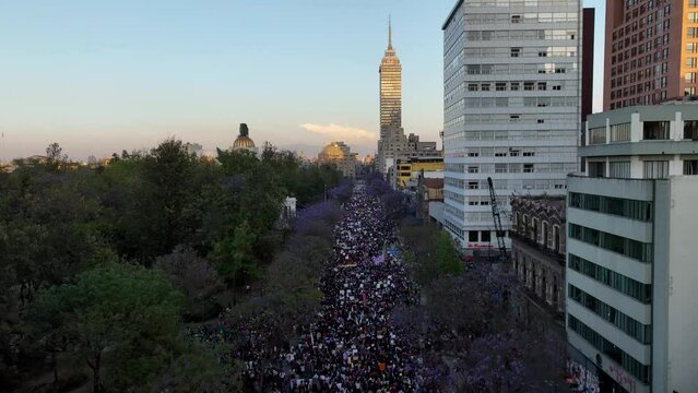 Aerial view of a feminist protest parade in Mexico city, during sunset