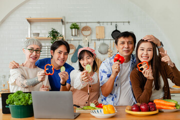 happy asian family in kitchen Make breakfast together on vacation. Warm families chat and cook together in the kitchen. Happy family. Father, mother and children. looking at camera.