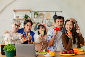 happy asian family in kitchen Make breakfast together on vacation. Warm families chat and cook together in the kitchen. Happy family. Father, mother and children. looking at camera.