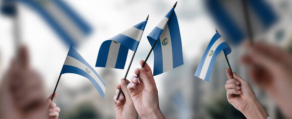 A group of people holding small flags of the Salvador in their hands - obrazy, fototapety, plakaty