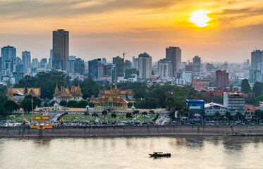 Obraz premium Phnom Penh river cruise boat passing the Royal Palace,at sunset,Cambodia.
