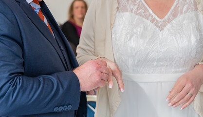 Brautpaar stecken sich die Trauringe nach der Trauung auf dem Finger
