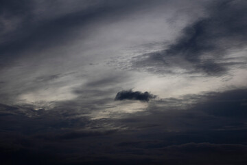 Obraz premium A cloud in the sky is dark and has a small hole in it.