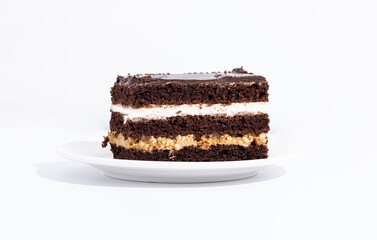 piece of chocolate cake with white cream on a white plate on a white background. horizontal photograph of a piece of close up cake