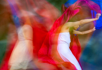 Mystical, blurry dance photo of adult woman with colorful fabric.