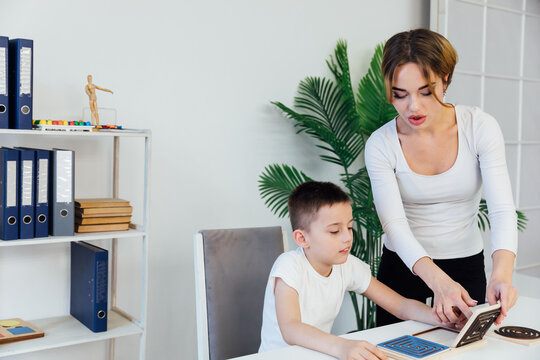 a boy with a psychologist in the office plays board games