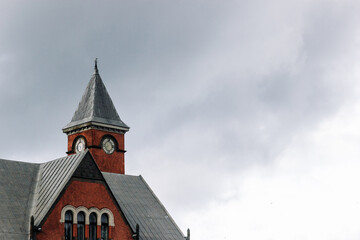 The top of an old building with a clock tower against an overcast sky.
