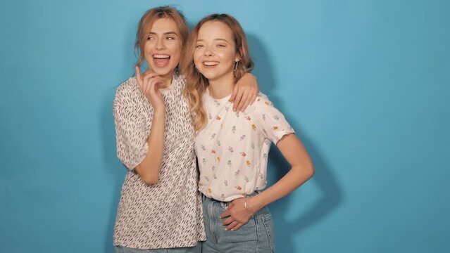 Two young beautiful smiling hipster girls in trendy summer clothes. Sexy carefree women posing in studio. Positive models having fun