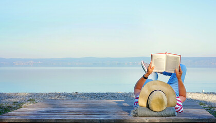Frau liest ein Buch am See