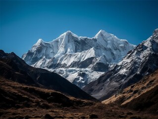 Obraz premium A majestic mountain range with snow-capped peaks and a clear blue sky