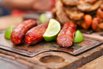 A plate of sausages with lemon on it, Colombia's favorite food, selective focus