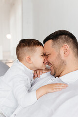 Dad plays with his little son on the sofa. Family pastime. Happy smiling people. 