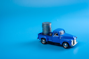 Toy car truck with money on blue background
