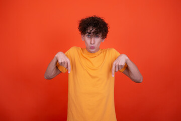 Young attractive guy and men's health problems. Emotional man. Orange background.