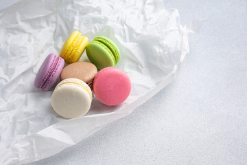Macarons in white kraft paper on the table
