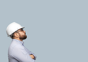ingeniero con casco blanco mirando hacia arriba 