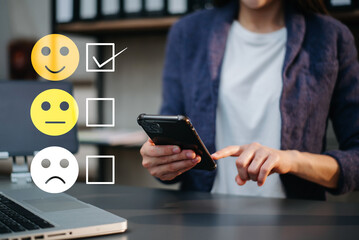 Customer service evaluation concept. woman Show face smile emoticon show on virtual screen from hand.looking at smart phone, tablet and laptop