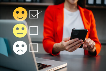 Customer service evaluation concept. woman Show face smile emoticon show on virtual screen from hand.looking at smart phone, tablet and laptop
