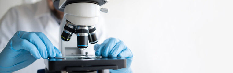 Medical laboratory, scientist hands using microscope for examining samples and liquid, Scientific...