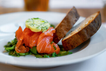 Marinated raw salmon (ceviche) with herb butter and rucola, bread
