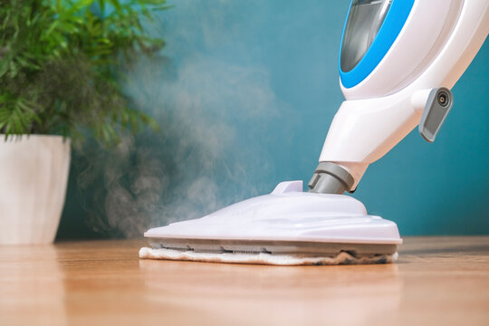 man washes floors with steam mop. Floor treatment with hot steam. Hygienic control of cleanliness.