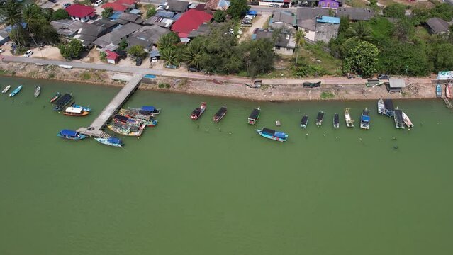 Aerial tilt to the left, fisherman village near the river in Besut, Terengganu, Malaysia. 4K.
