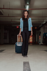 A business woman with a suitcase set in a modern garage while going to the airport. Business travel concept