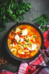 Warming autumn soup with red lentils, chicken fillet, vegetables, spices and paprika, comfort food. Green table, top view