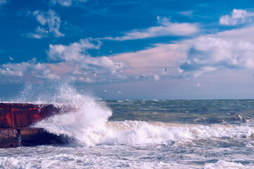    Huge wave crashing on the pier on a sunny stormy day
