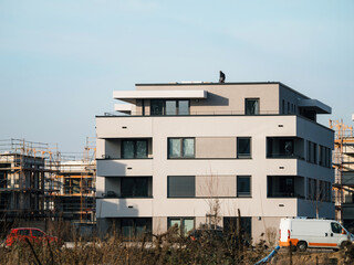 Fototapeta premium A stunning new tower block of dream apartments stands in a residential area, constructed by skilled workers in the construction industry.