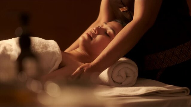 Relaxation Asian woman customer get service aromatherapy massage neck and shoulder with masseuse in spa salon.