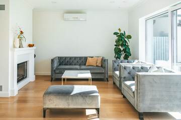 Naklejka na ściany i meble Cozy white living room with elegant sofas and fireplace