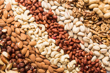 different nuts background. Close up, top view, flat lay. Walnut, pistachios, almonds, hazelnuts and cashews