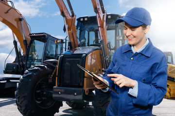Woman with digital tablet on the background of construction machines	