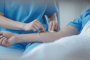 Injured patient showing doctor broken wrist and arm with bandage in hospital office or emergency room. Sprain, stress fracture or repetitive strain injury in hand. Nurse helping customer. First aid.