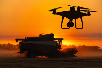 Silhouettes of combine harvester and drone	