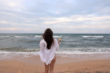 Woman with a glass of wine on the seashore.Concept of rest and relaxation. Summer weekend. Voucher. Tourism.